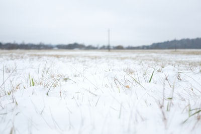 a field covered in snow with a tower in the distance
